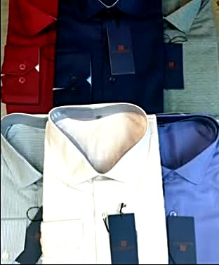 Camisas sociais dobradas na loja Brasil Roupas